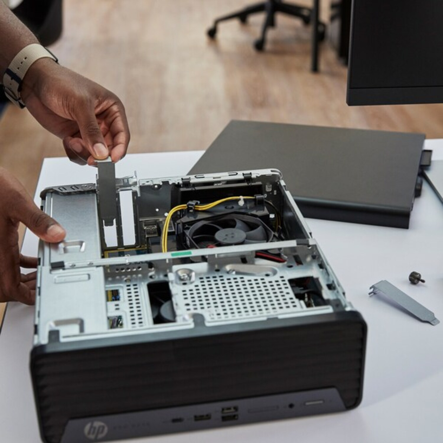 Handen die een desktopcomputer in elkaar zetten, componenten zichtbaar.