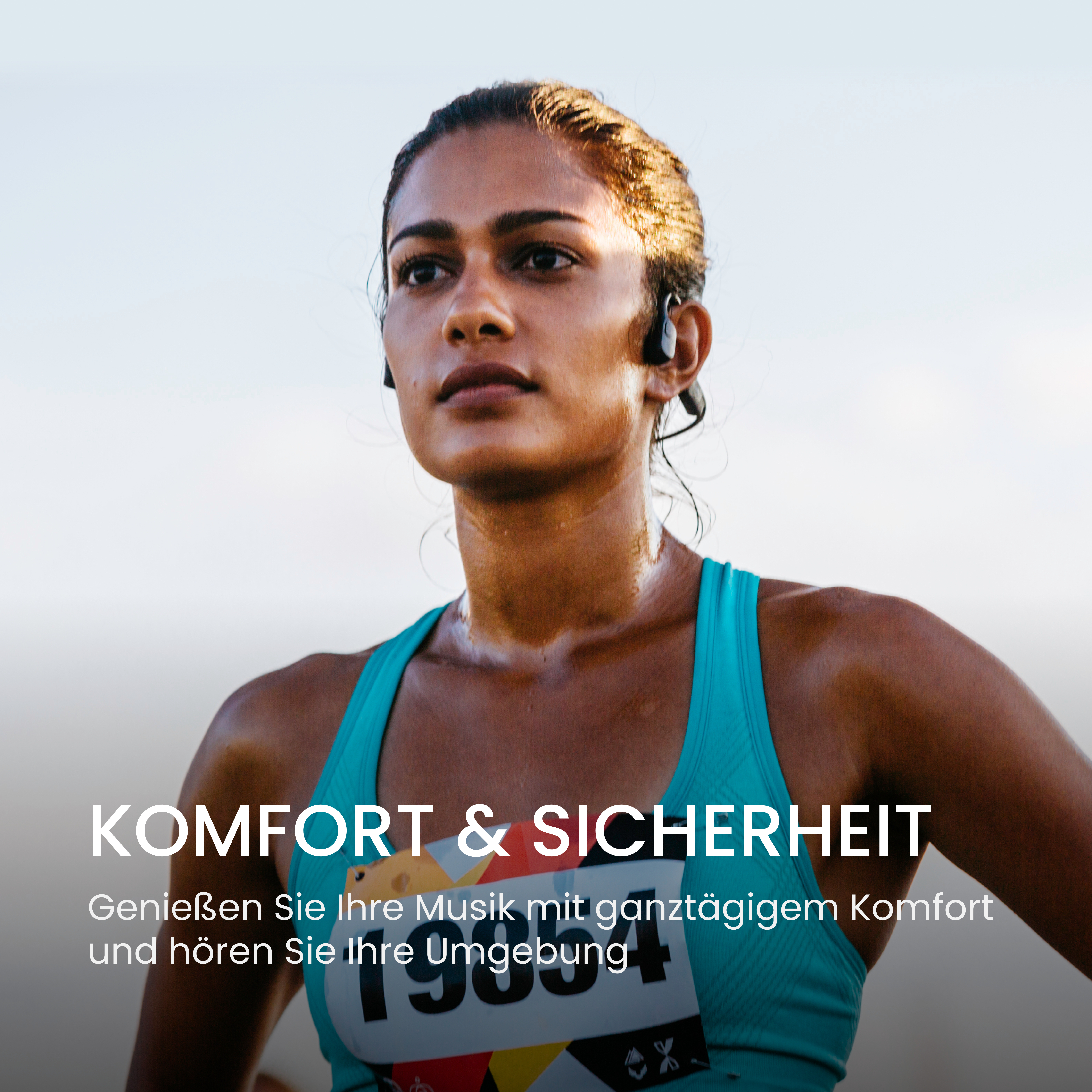 Eine Frau mit Kopfhörern, einem türkisfarbenen Oberteil und einer Startnummer. Schweiß glänzt auf ihrer Haut. Text: 'KOMFORT & SICHERHEIT'.