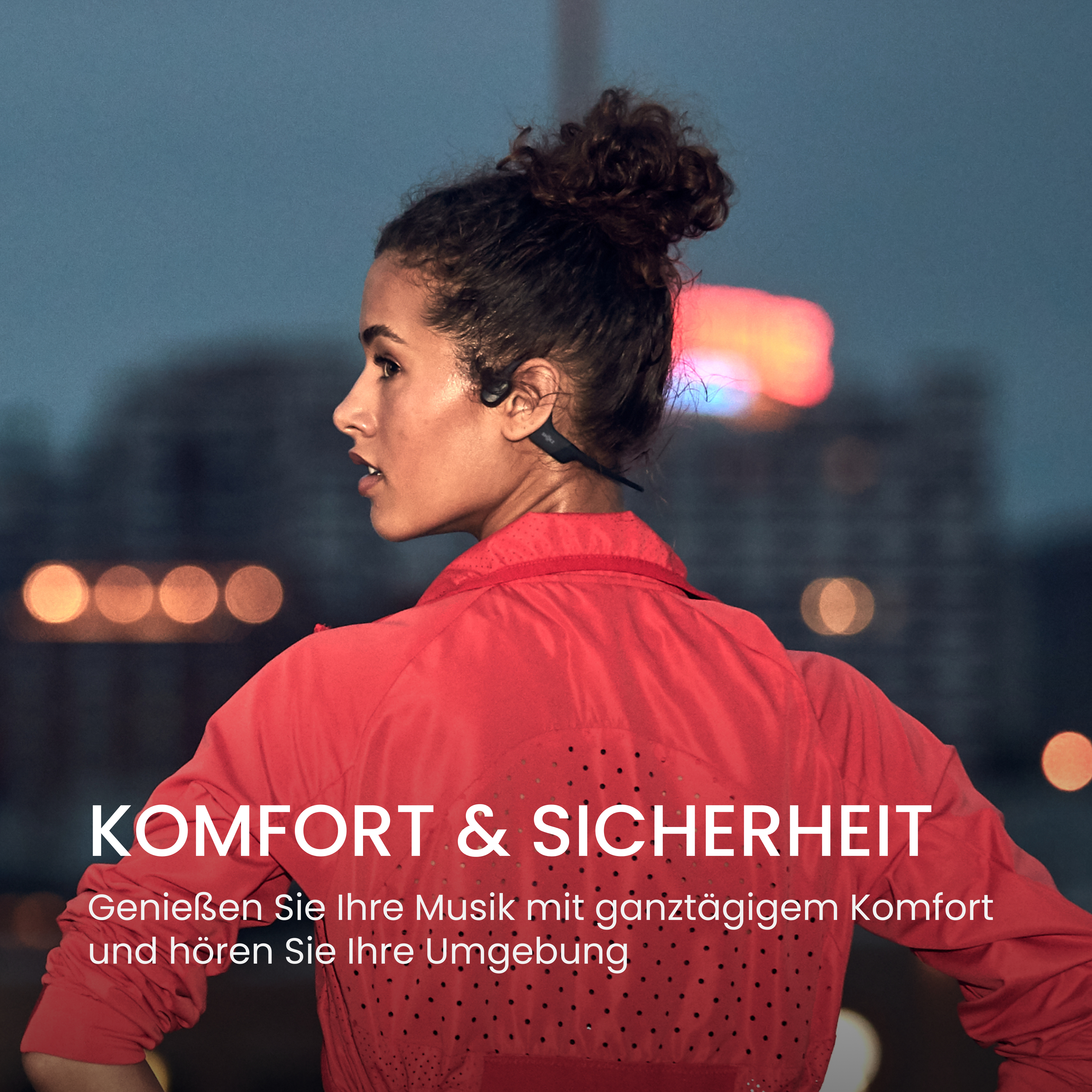 Eine Frau in roter Jacke mit Kopfhörern, die wegschaut. Der Hintergrund ist verschwommen, mit Text 'KOMFORT & SICHERHEIT'.