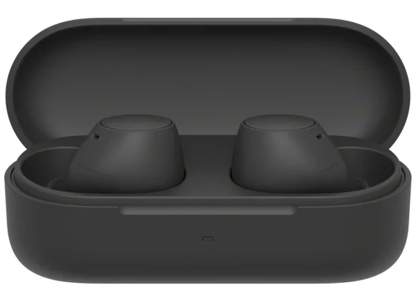 Czarne słuchawki w otwartym czarnym etui ładującym. Etui jest owalne.