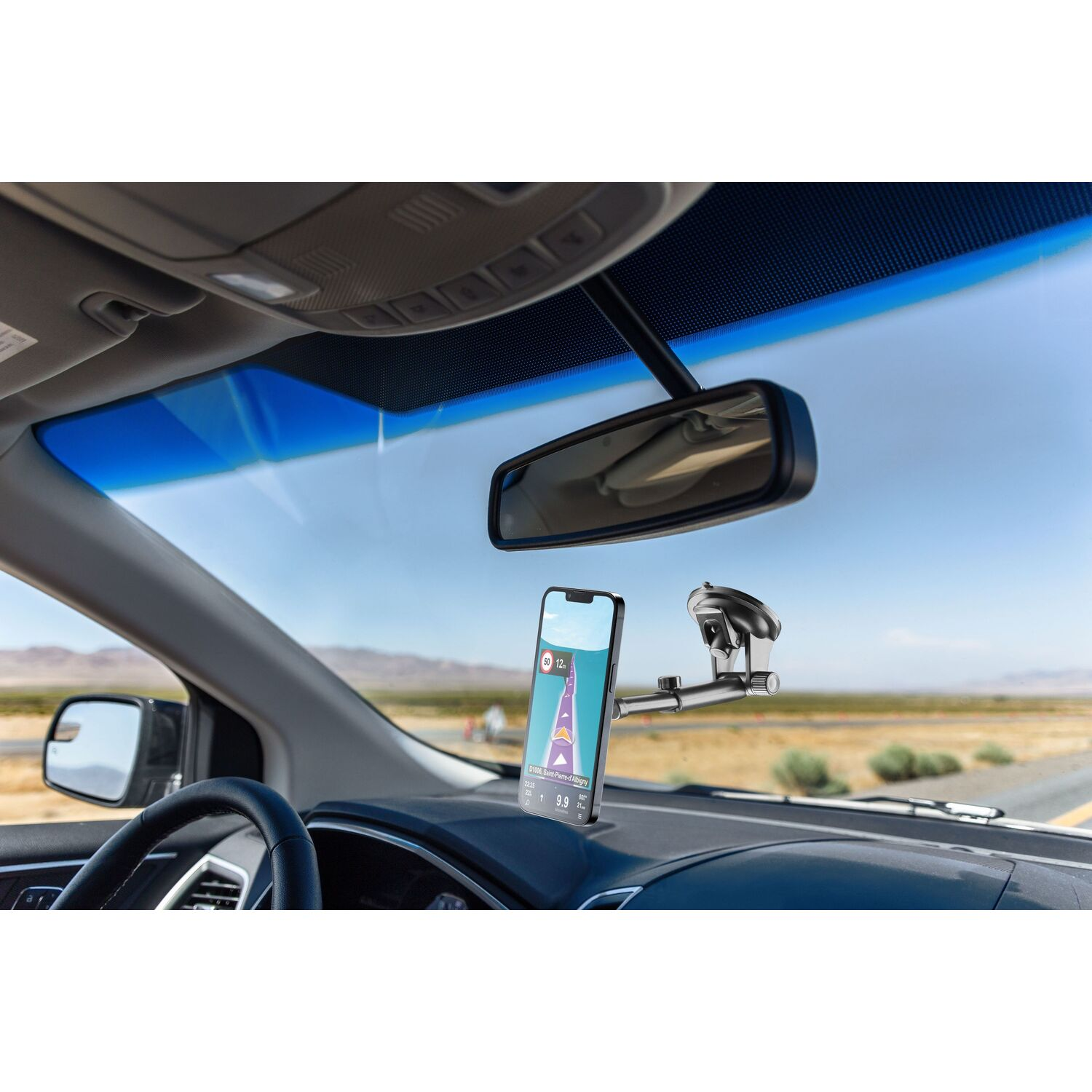 Intérieur de voiture avec un téléphone monté sur le tableau de bord. La carte GPS est affichée sur l'écran du téléphone.