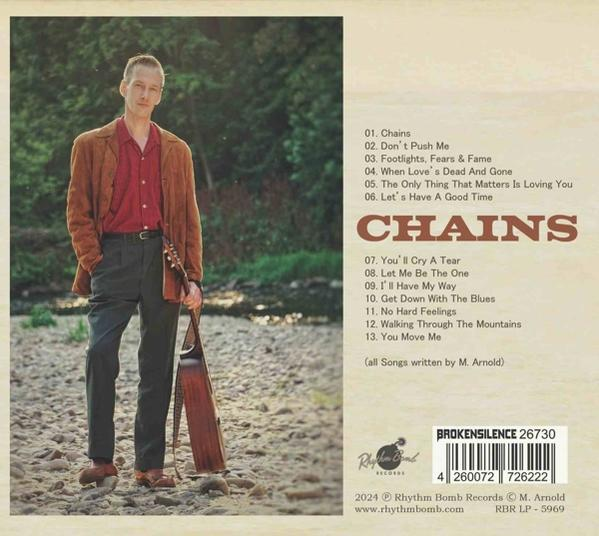 Ein Mann mit Gitarre, Albumcover, Chains, mit Songtiteln und Logo.