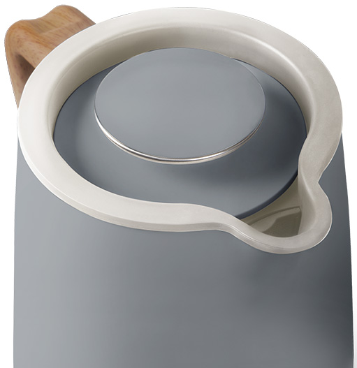 Un bollitore grigio con manico bianco e impugnatura in legno sulla parte superiore, isolato.