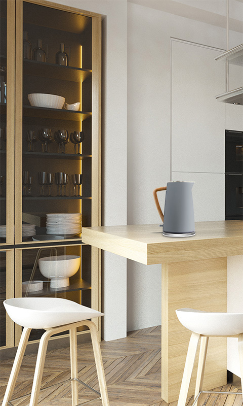 Una cucina moderna con un'isola in legno chiaro, sgabelli e un armadio con ante in vetro.
