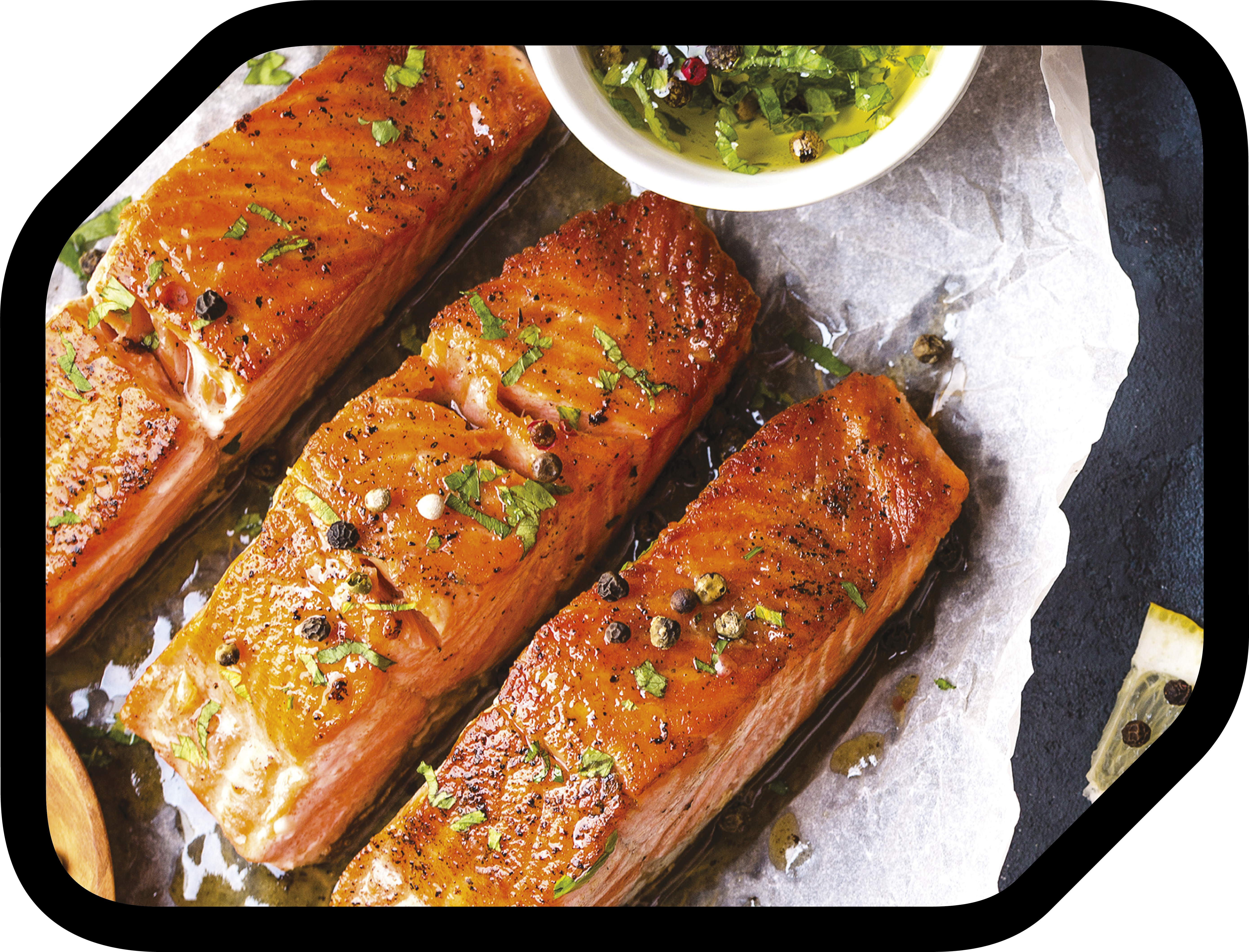 Filets de saumon grillés aux herbes et grains de poivre, sur papier sulfurisé.