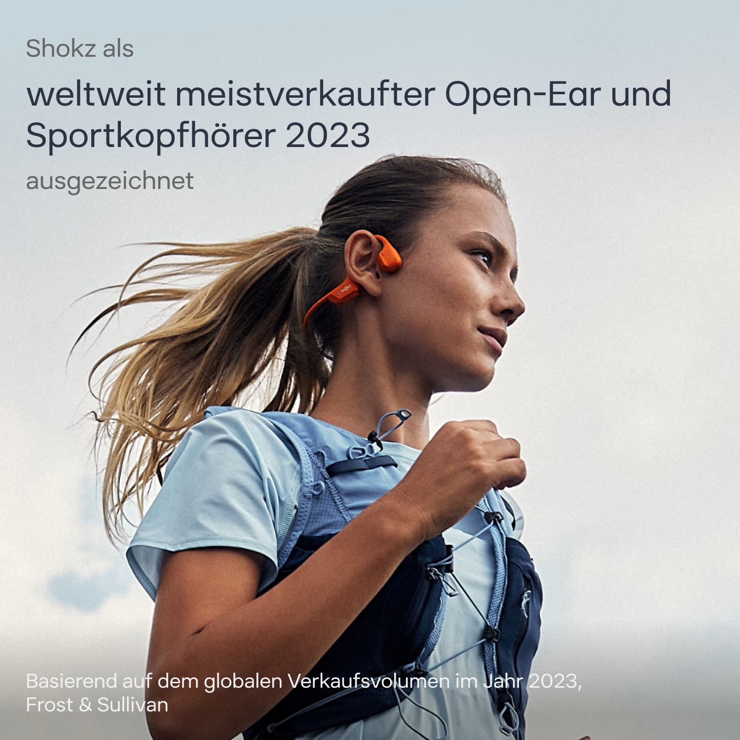 Frau beim Laufen mit orangenen Shokz-Kopfhörern. Text über Open-Ear-Kopfhörer.