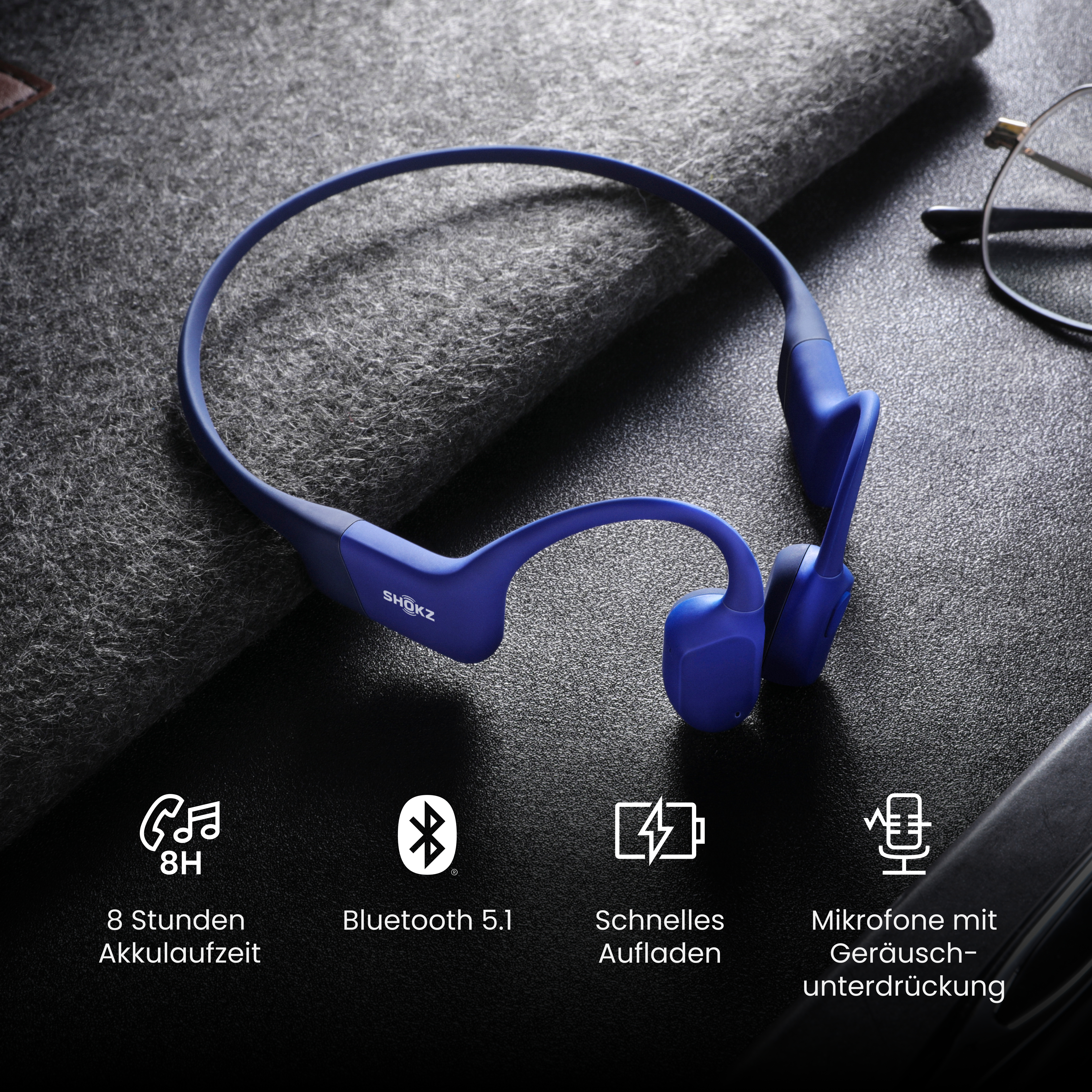 Blaue Knochenschallkopfhörer auf dunkler Oberfläche, mit Symbolen für Funktionen wie Bluetooth und Akkulaufzeit.