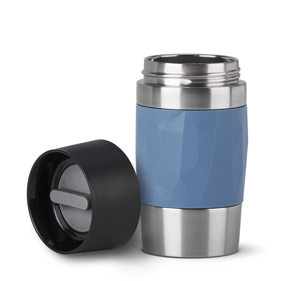 Taza de viaje aislada azul y plateada, con la tapa separada, fondo blanco.