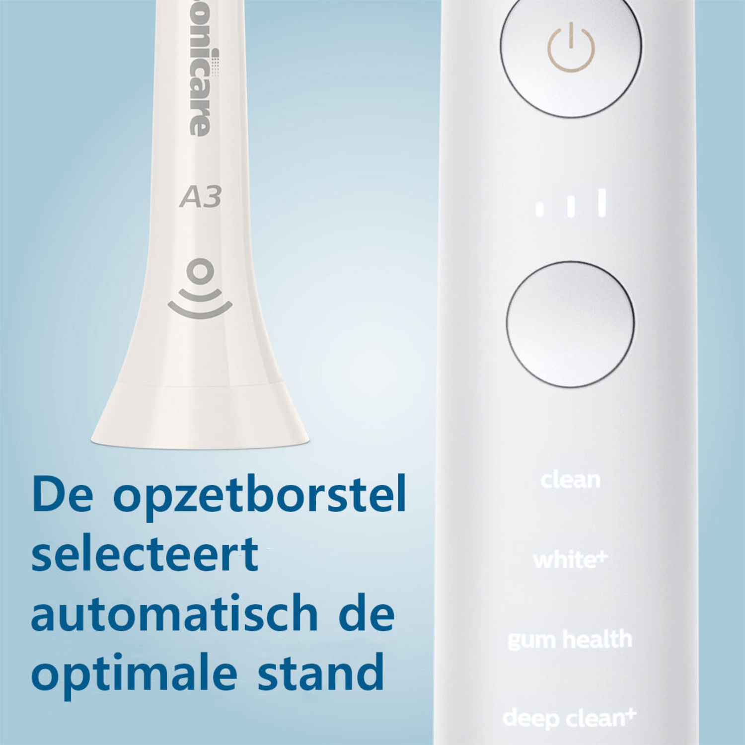 A white electric toothbrush with labels and a power button, close up.