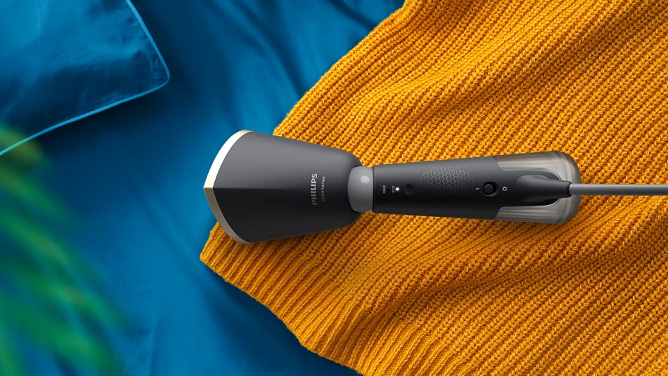 Parownica Philips na niebieskim i pomarańczowym tle, z żółtym swetrem.