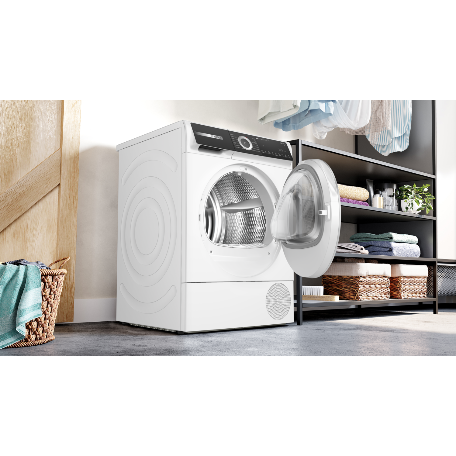 A white washing machine with an open door next to a basket and shelving.