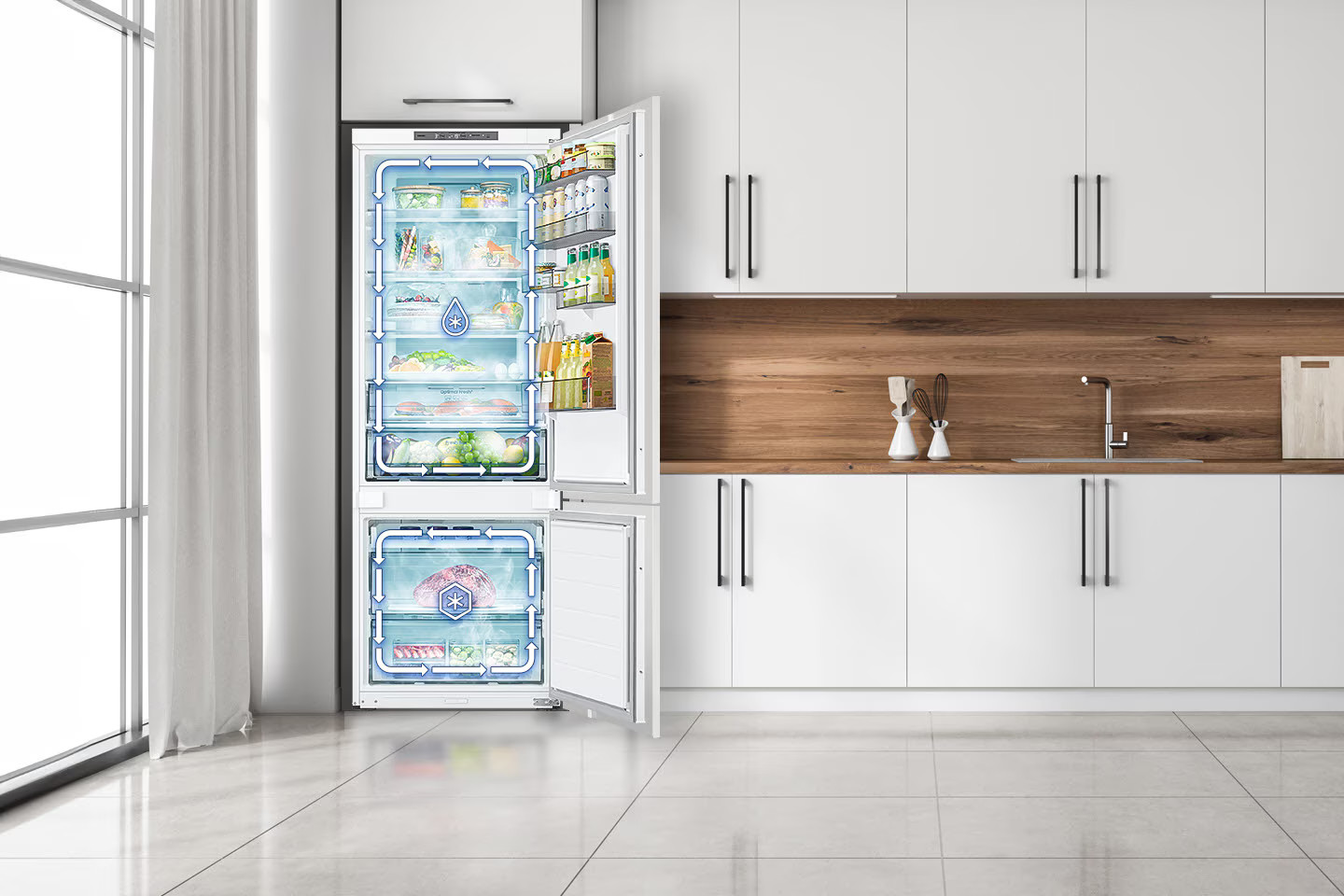 Biała lodówka z otwartymi drzwiami, pokazująca zawartość. Kuchnia z białymi szafkami, drewnianymi akcentami i oknem.