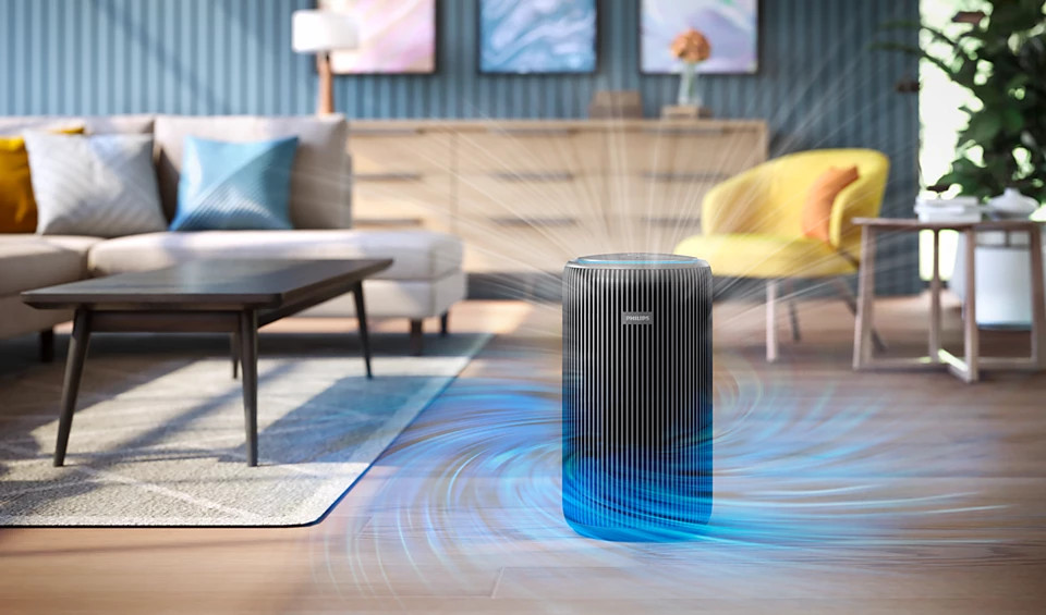 Oczyszczacz powietrza w salonie, z niebieskim przepływem. Widoczna sofa, stół i rośliny.