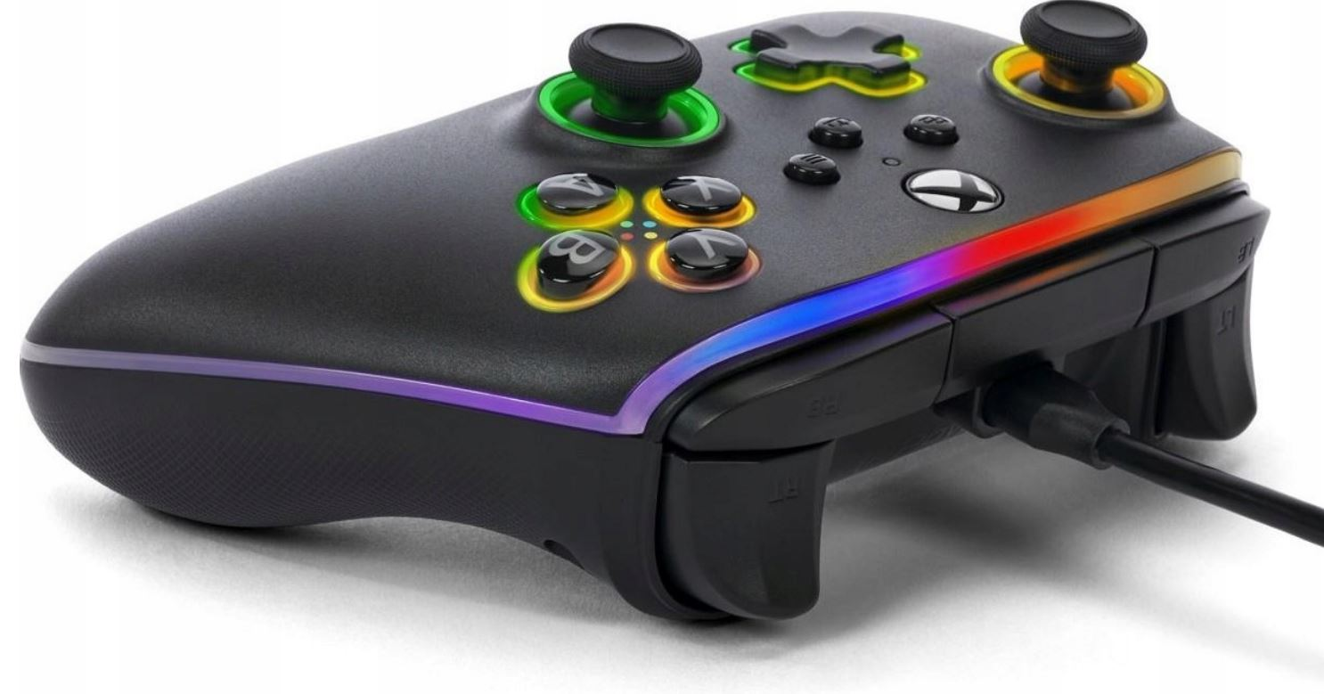 Czarny kontroler do gier z kolorowymi przyciskami i akcentami. Podłączony jest kabel ładujący.