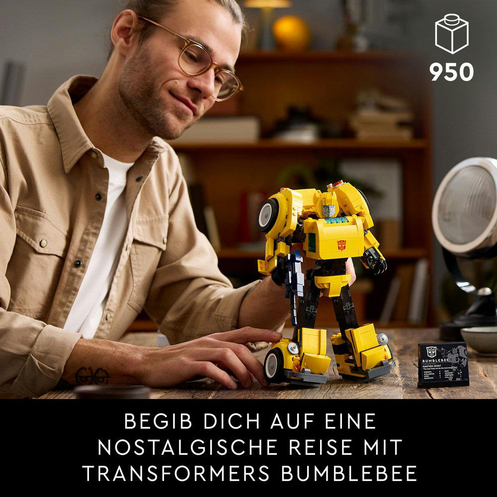 Ein Mann mit Brille baut einen gelben Lego Transformer zusammen. Das Set enthält eine Karte und eine Box.