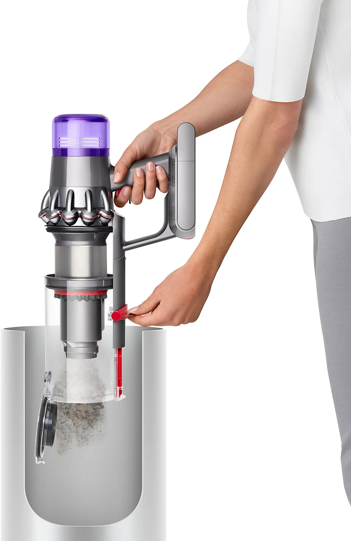 Une personne vide un aspirateur dans une poubelle.