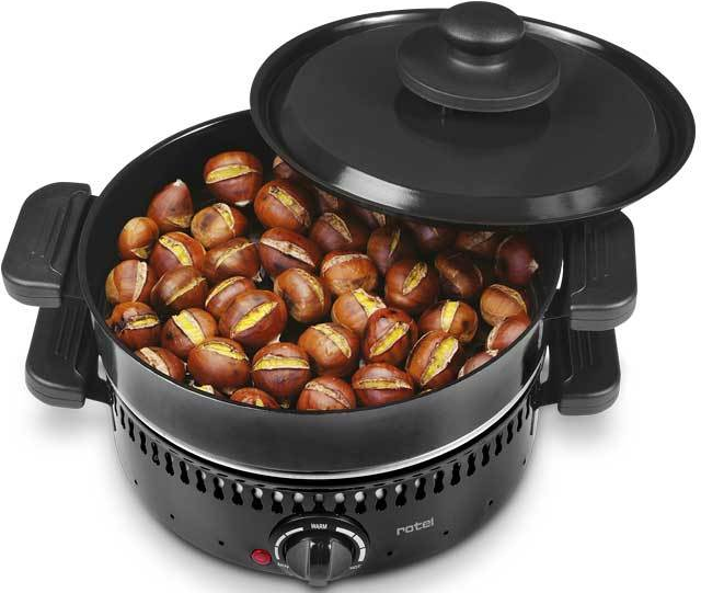 Un rôtissoire à châtaignes noir, rempli de châtaignes grillées avec son couvercle ouvert.