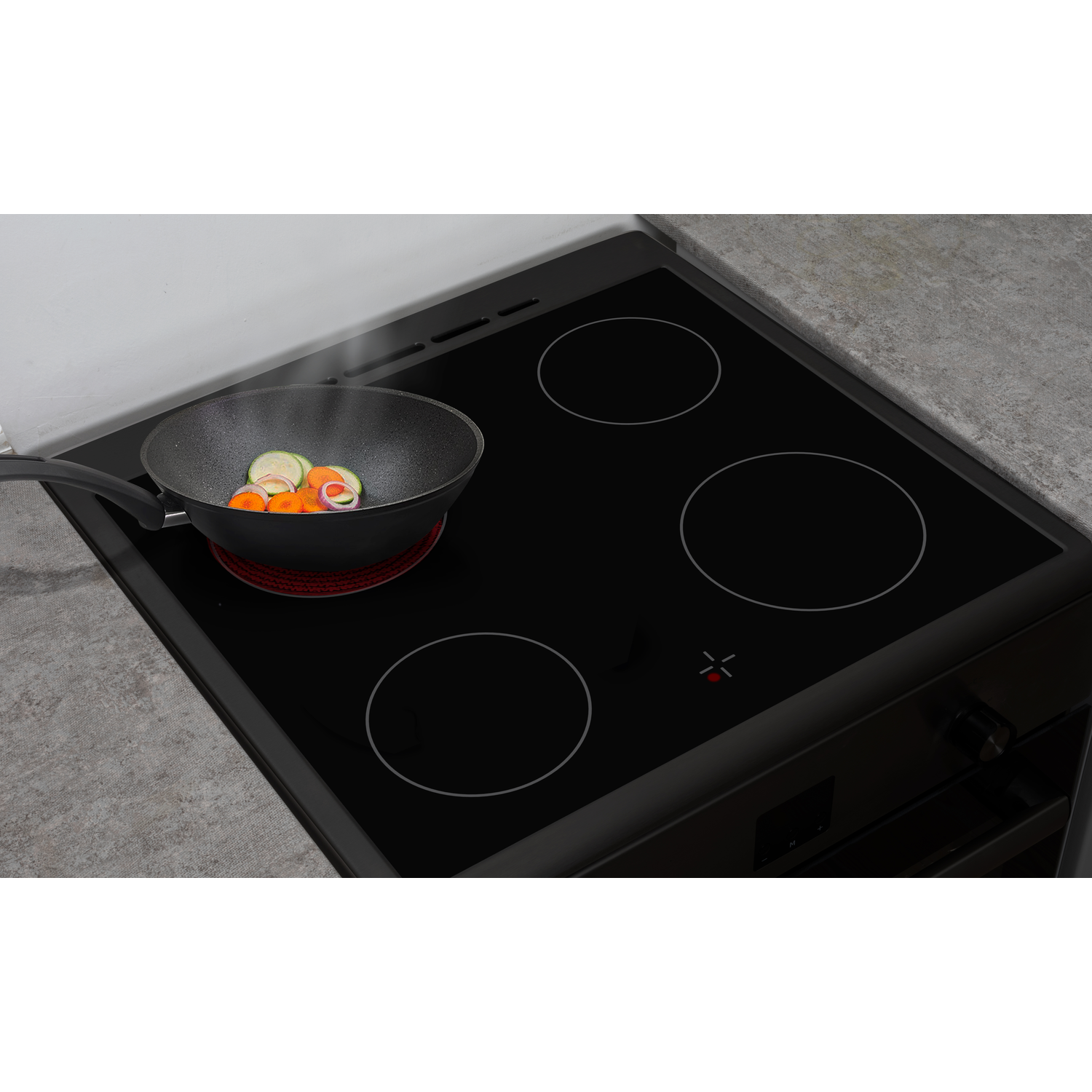 Zwart fornuis met vier branders. Een pan met eten staat op de linkerbrander.