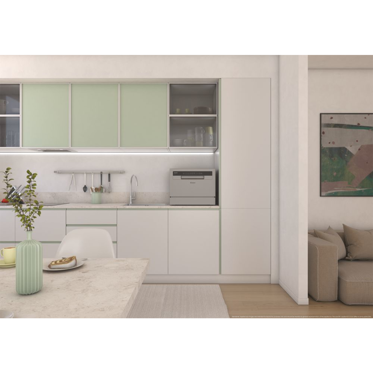 Una cucina con mobili bianchi, una lavastoviglie e un tavolo con un vaso e un piatto. Un divano sullo sfondo.