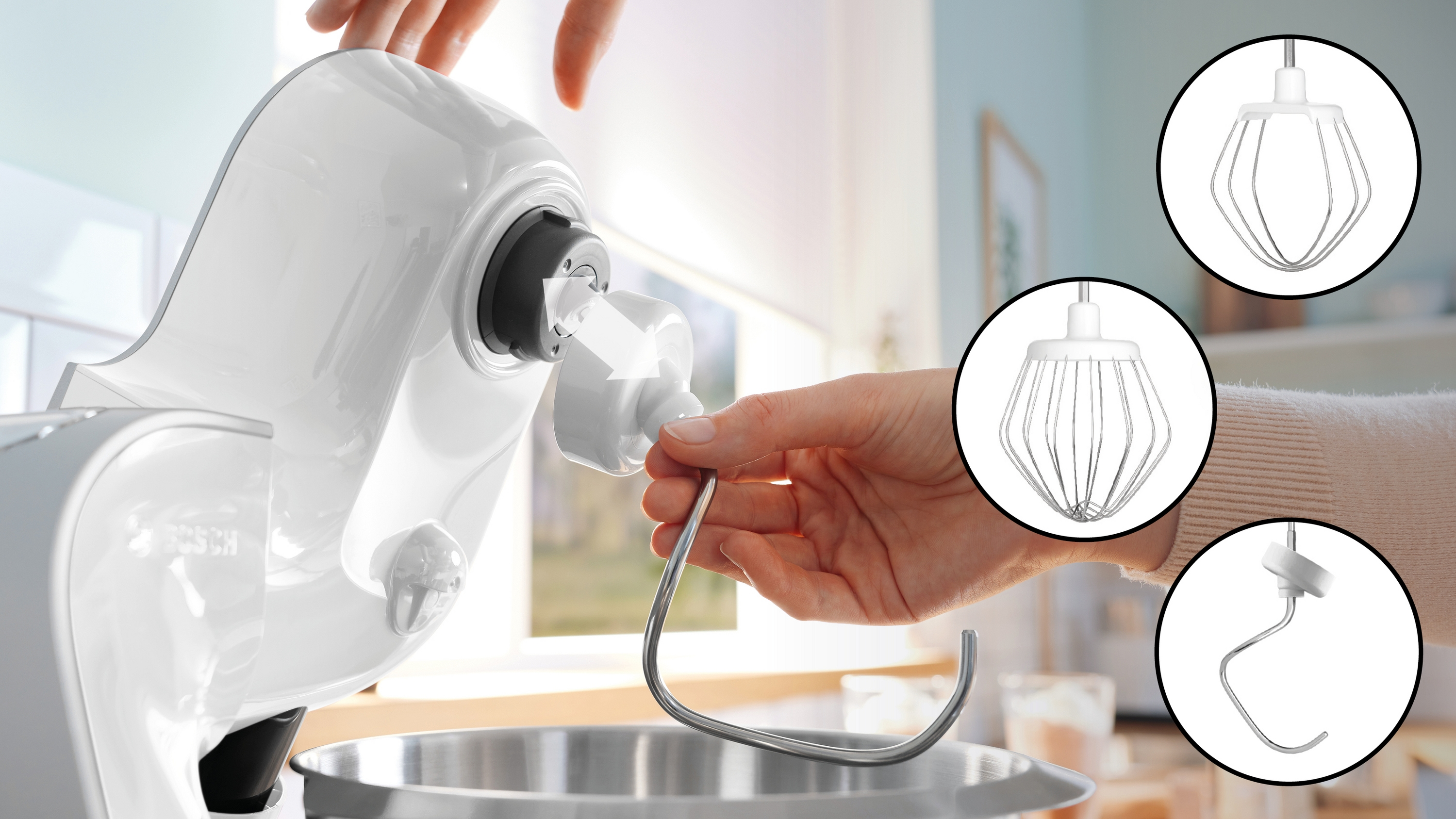 Eine Hand befestigt einen Schneebesen an einem weißen Standmixer. Weißer Hintergrund.