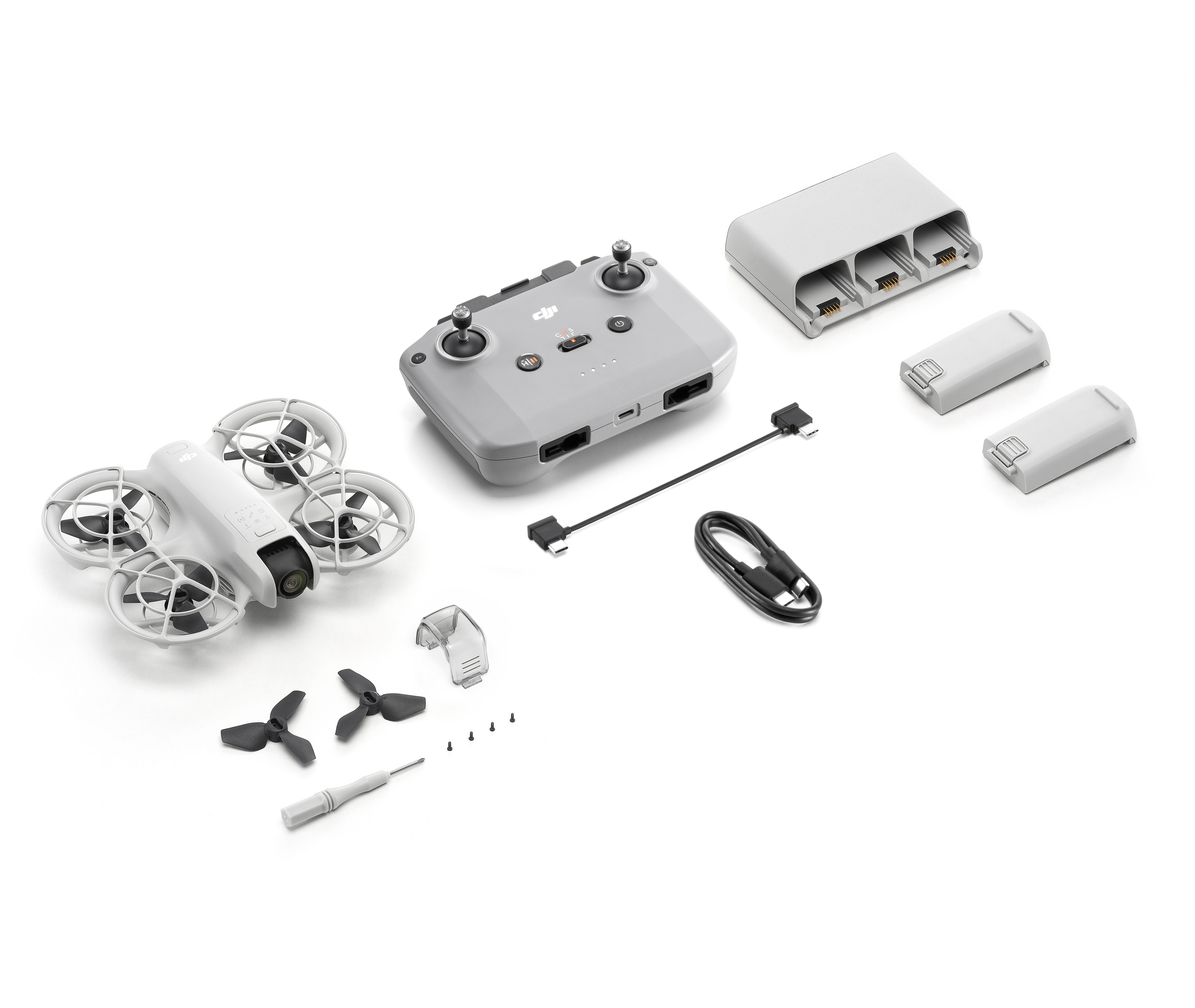 Eine DJI-Drohne und Zubehör: Controller, Ladegerät, Akkus, Propeller und Werkzeuge.
