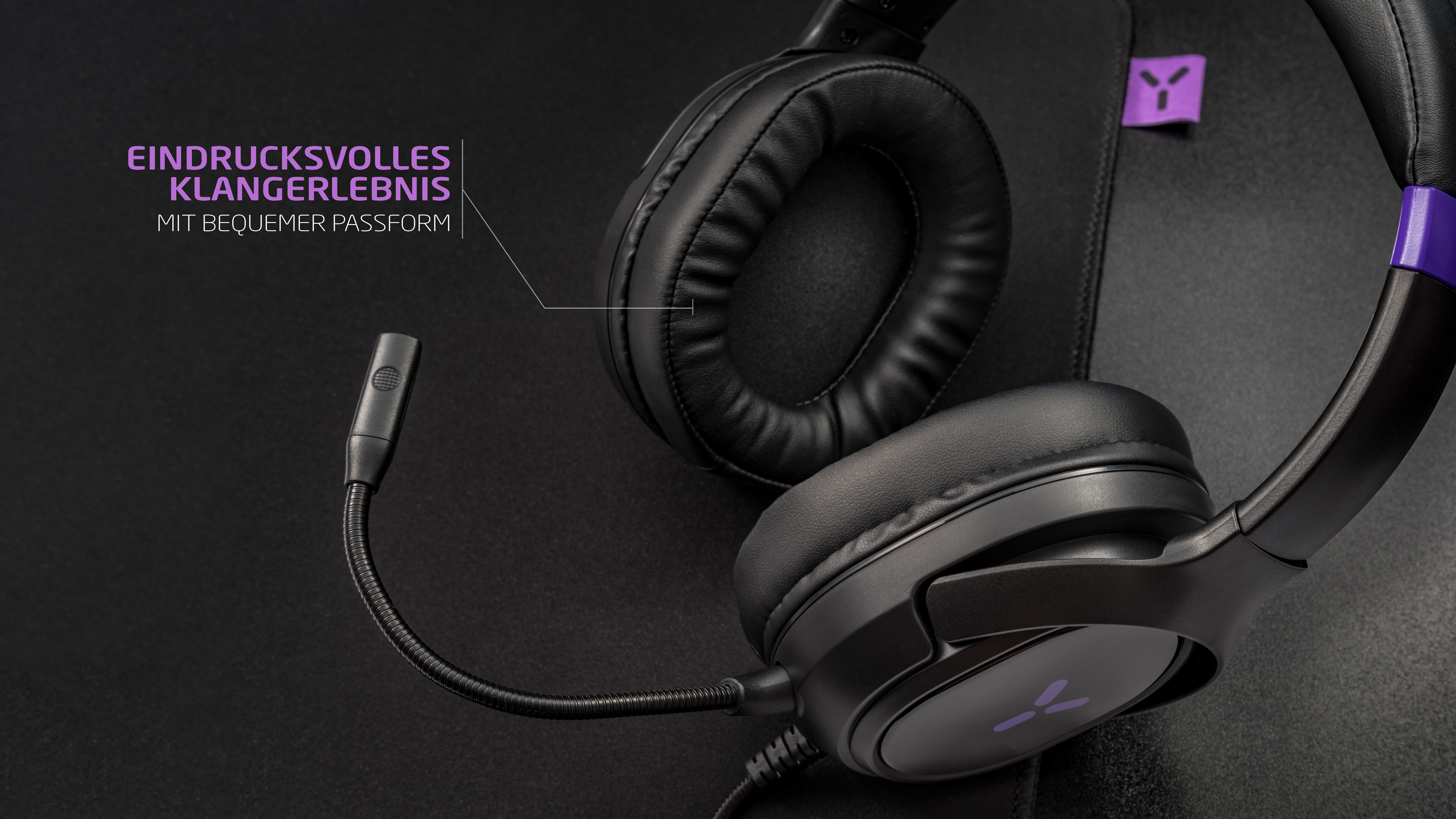 Schwarzes Gaming-Headset mit Mikrofon auf schwarzer Oberfläche mit Text: 'beeindruckender Klang'.