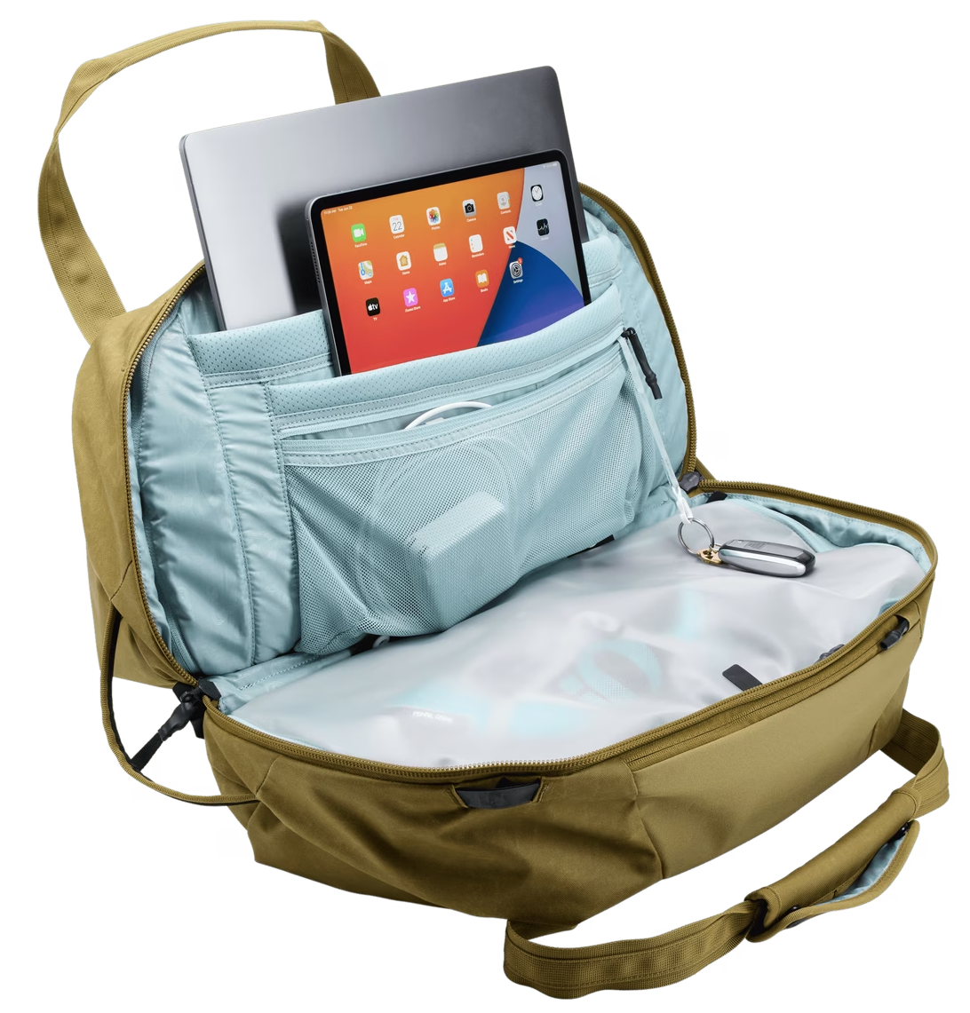 Nyitott olívazöld hátizsák laptop-pal és tablettel. Más tárgyak is láthatók.