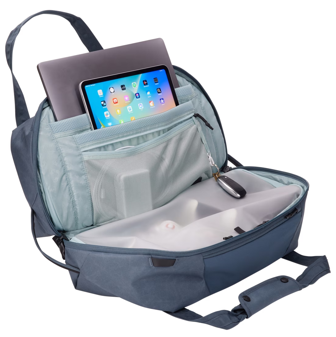 Nyitott hátizsák laptop, tablet és kiegészítőkkel. Belső zsebek és hálós rekesz látható.