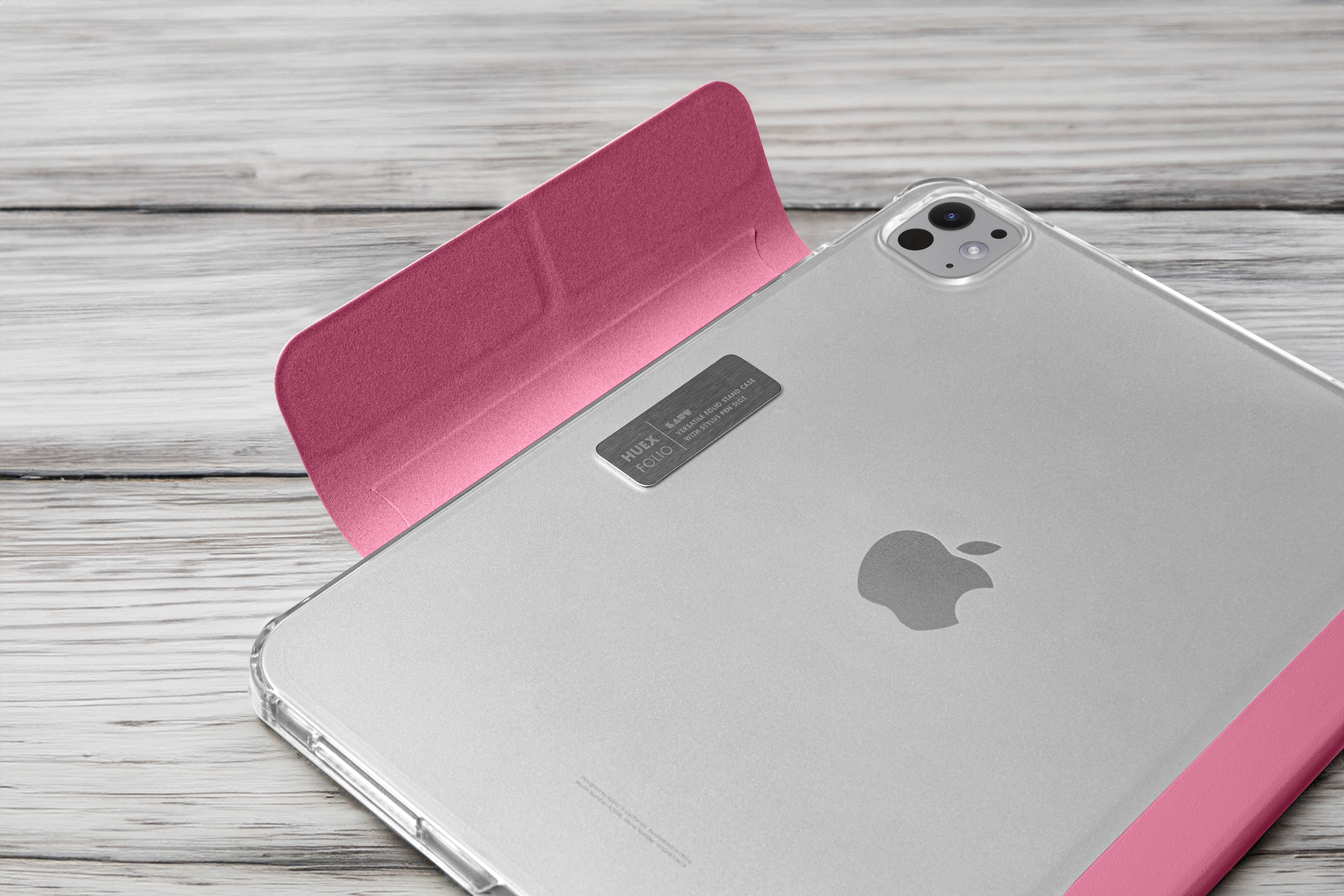Silbernes iPad mit rosa Hülle auf Holz. Apple-Logo sichtbar.