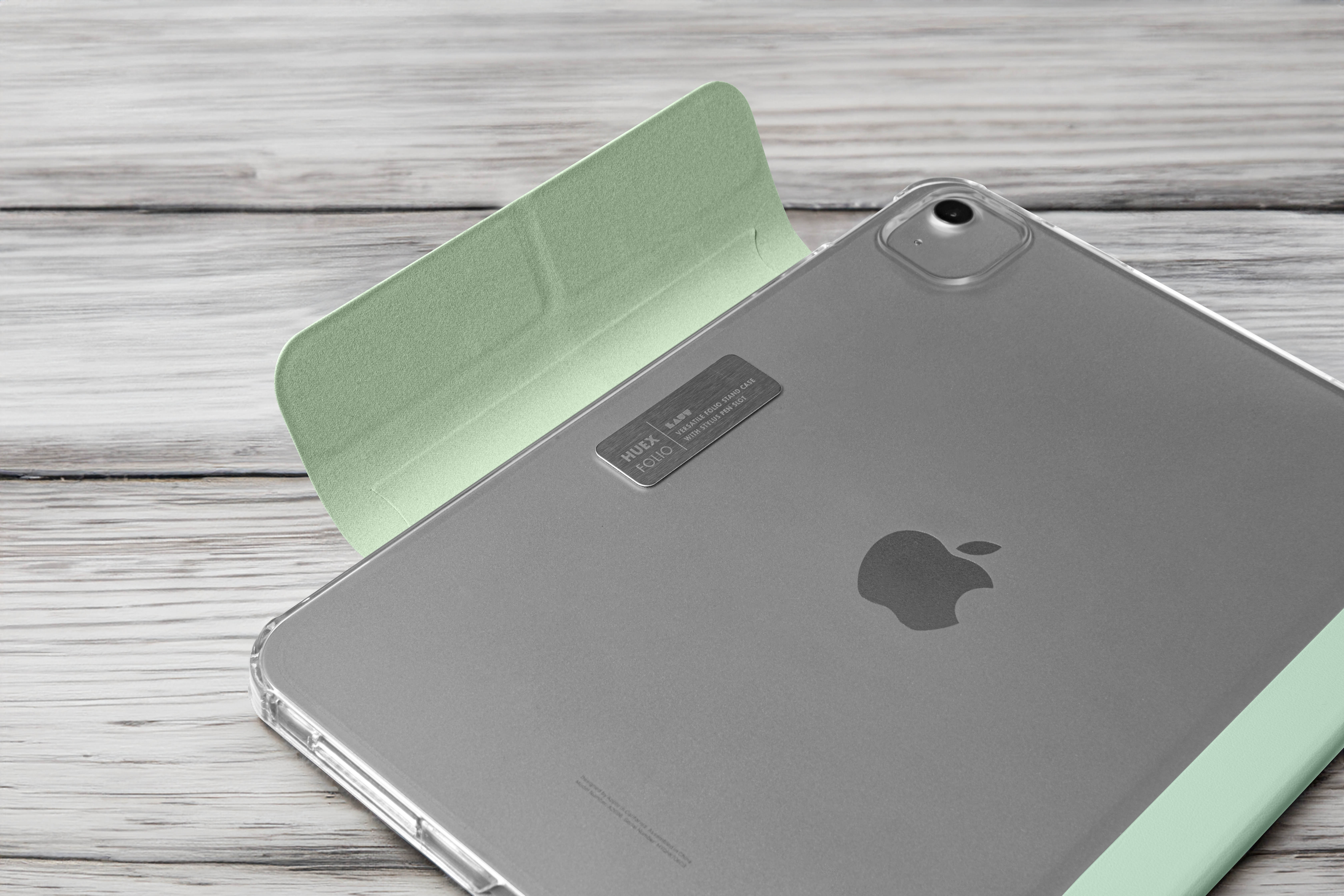 Ein silbernes iPad mit hellgrünem Case liegt auf einer Holzoberfläche. Das Apple-Logo ist sichtbar.