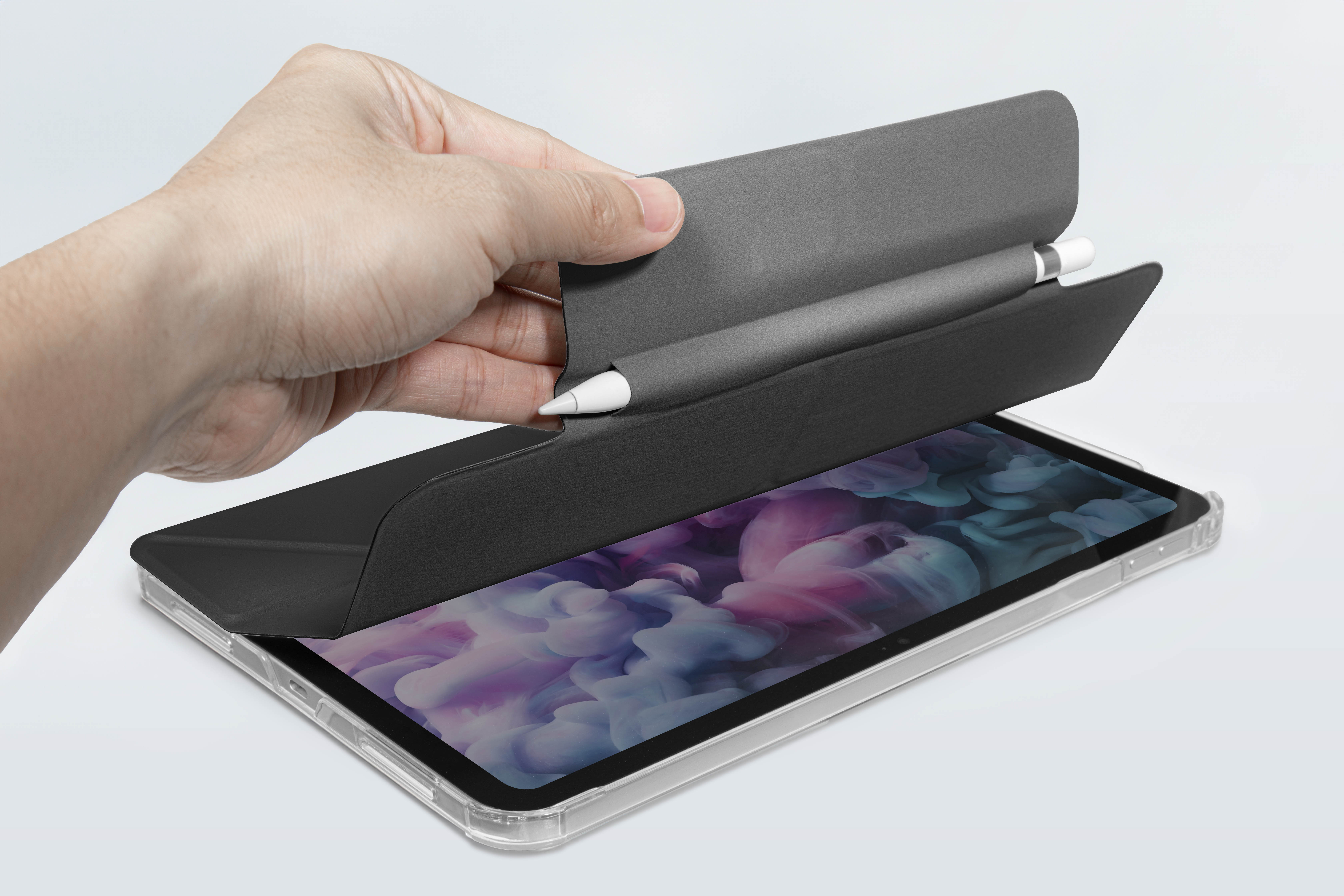Une main ouvre une couverture pour révéler une tablette avec un crayon dans un étui.