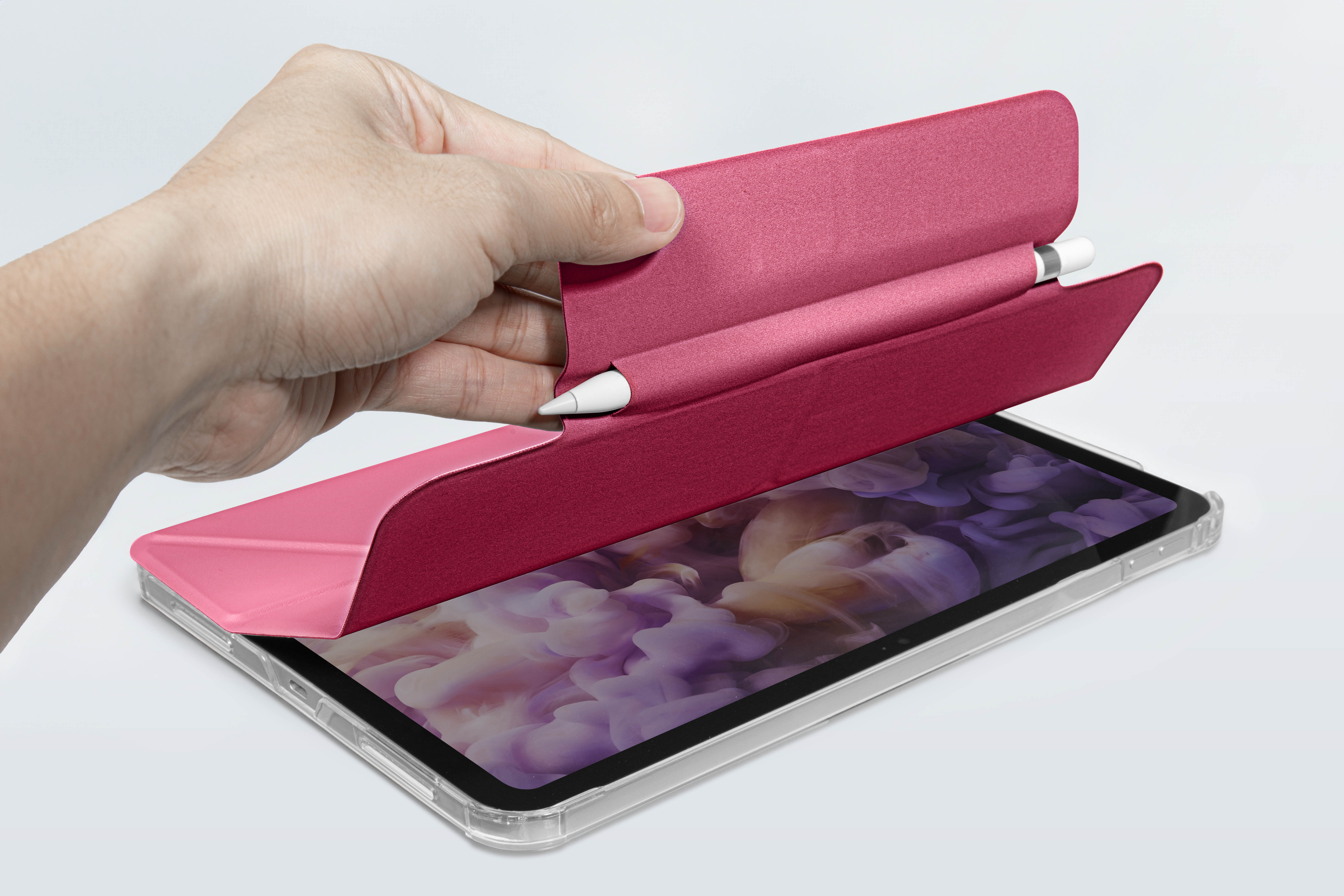 Eine Hand öffnet eine rosa Tablethülle mit einem Stift darin, über einem Tablet.