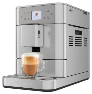 Eine silberne Kaffeemaschine mit einer Tasse Cappuccino davor. Die Maschine hat einen Bildschirm.