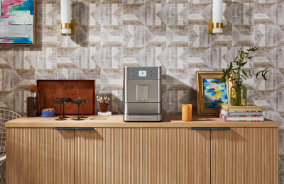 Eine moderne Küche mit einer Kaffeemaschine auf einer Holztheke mit Dekoration und Wandleuchten.
