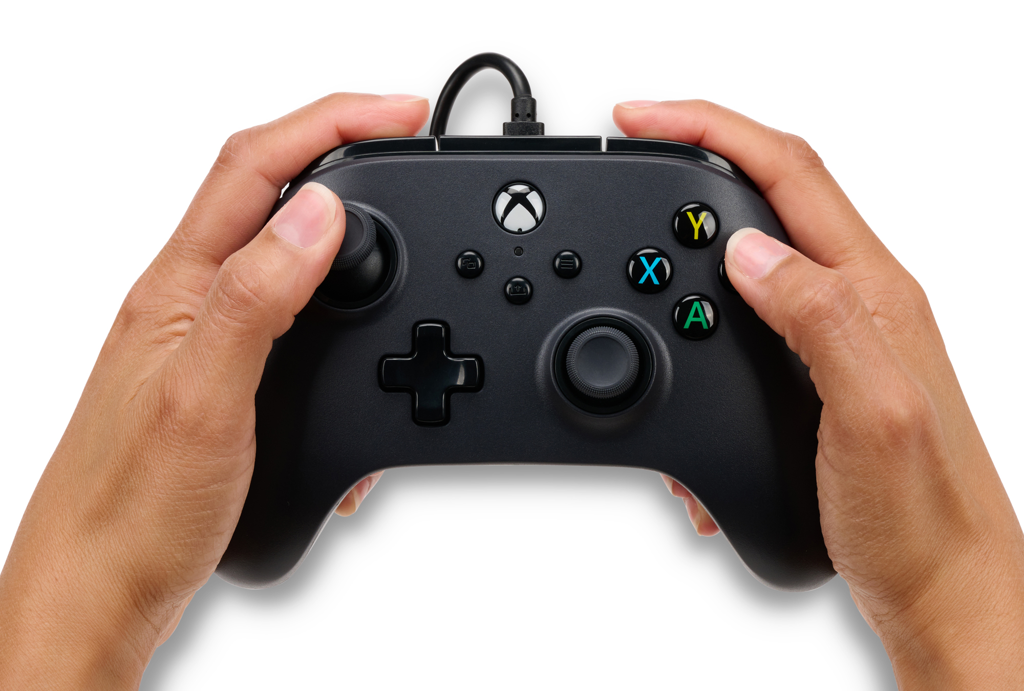 Renkli düğmeli siyah bir Xbox denetleyicisi tutan eller. Arka plan beyaz.