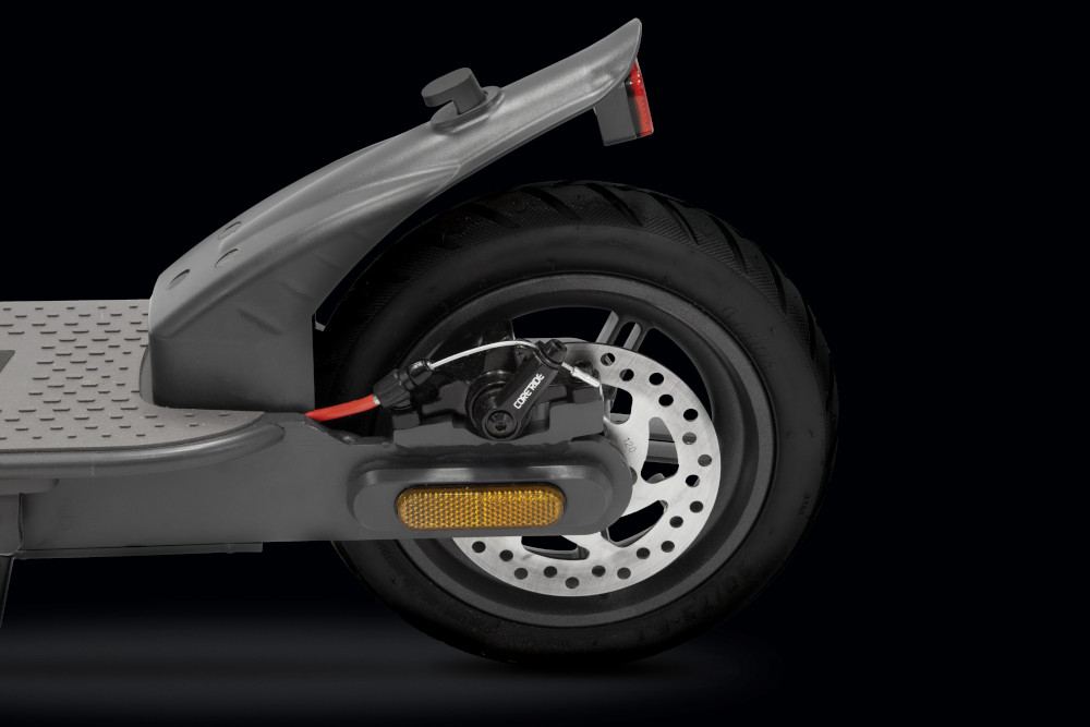 Rear wheel of a gray electric scooter, with black tire and brake disc.