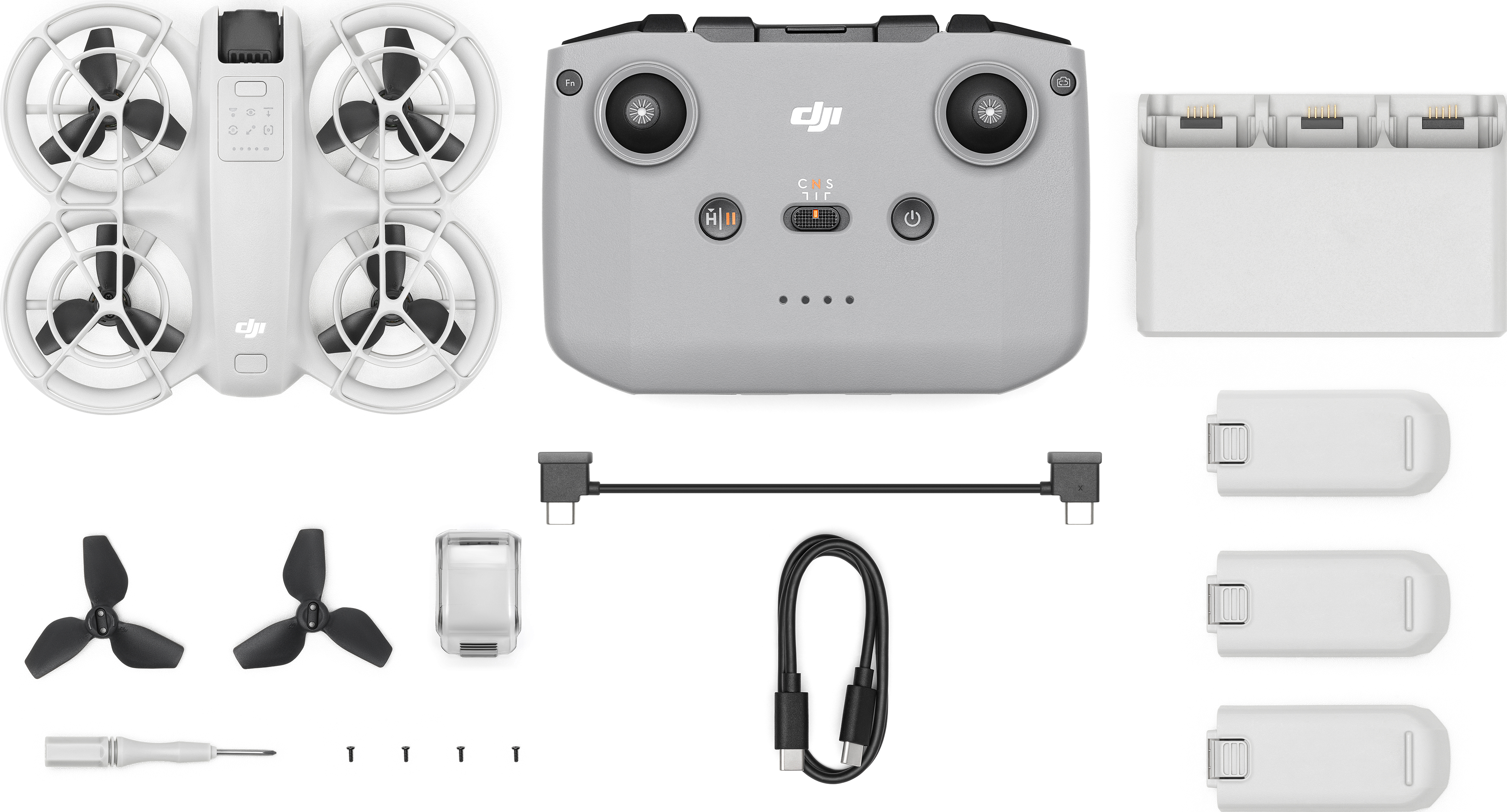 Drone, télécommande, chargeur de batterie et accessoires comme hélices, tournevis et câble.