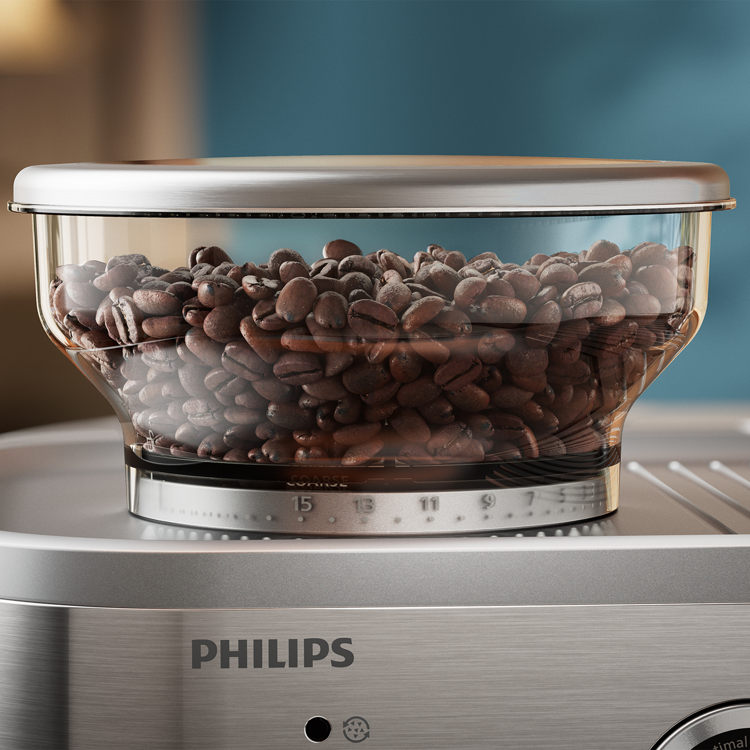 Een close-up van een koffiemolen. Het is een glazen container met koffiebonen. De basis is zilver. Philips-logo.