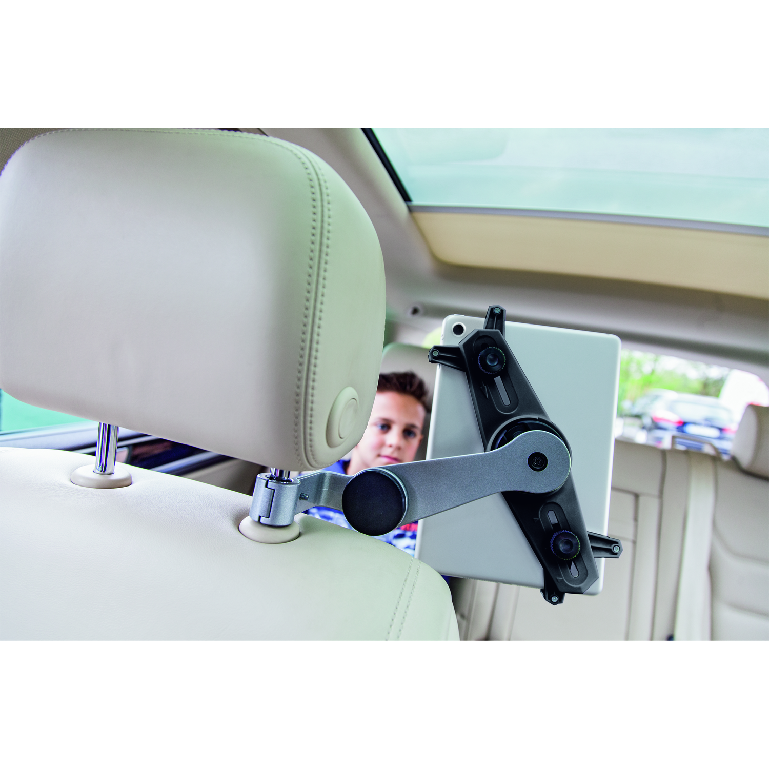 Tablet mounted on headrest of car. A person is visible in the background.