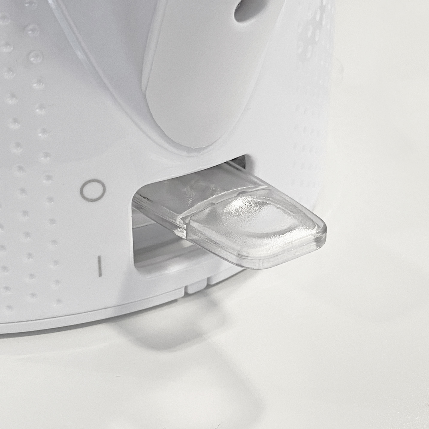 A close-up of a white electric kettle's power switch, showing the on/off position.