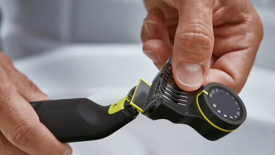 Ręka osoby reguluje nakładkę Philips OneBlade do trymera.