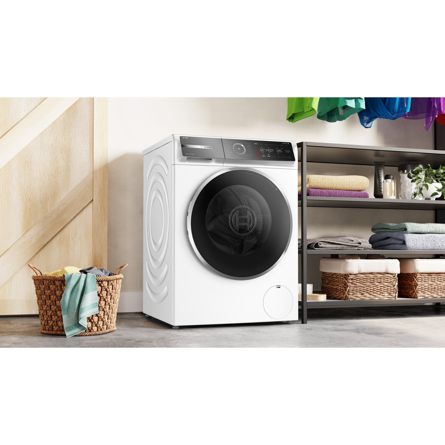 A white washing machine next to a storage shelf.