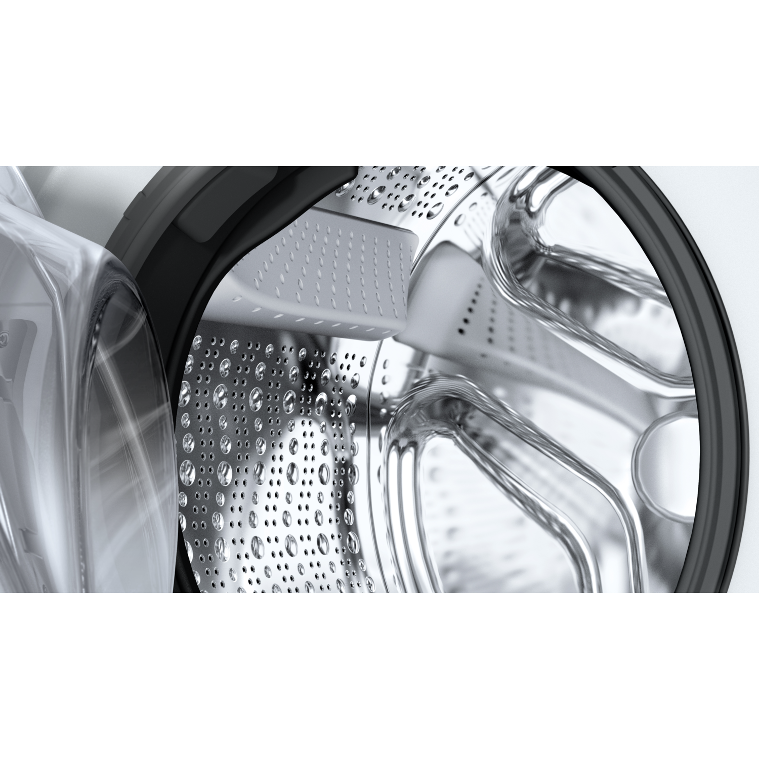 Close up inside a washing machine drum. Water droplets are visible on the stainless steel drum.