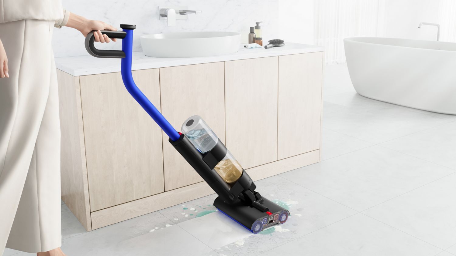 Personne nettoyant le sol avec un aspirateur bleu et noir, dans une salle de bain.