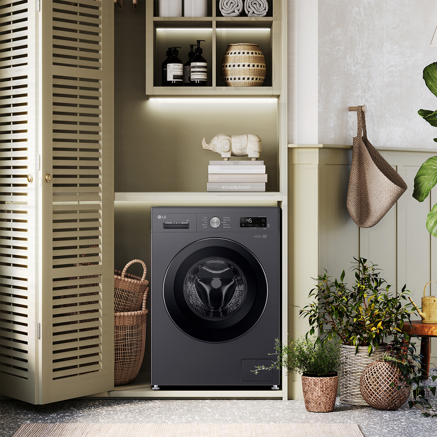 Lavatrice LG grigio scuro in una lavanderia dai colori chiari con piante e cesti.