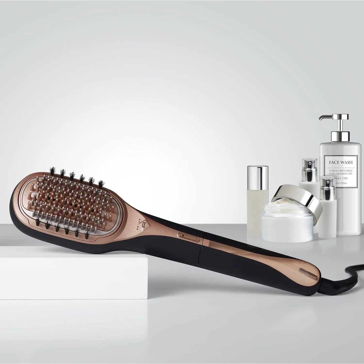 Una spazzola per lisciare i capelli e prodotti di bellezza su una superficie bianca.