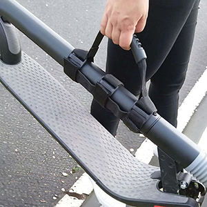 Eine Person hält einen Rollergriff mit schwarzem Griffband. Der Roller ist grau.