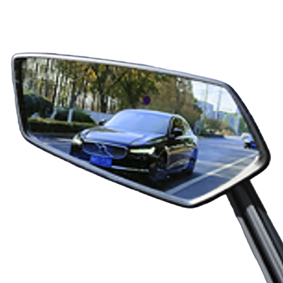 Ein Auto spiegelt sich im Seitenspiegel, mit Straße und Bäumen sichtbar.