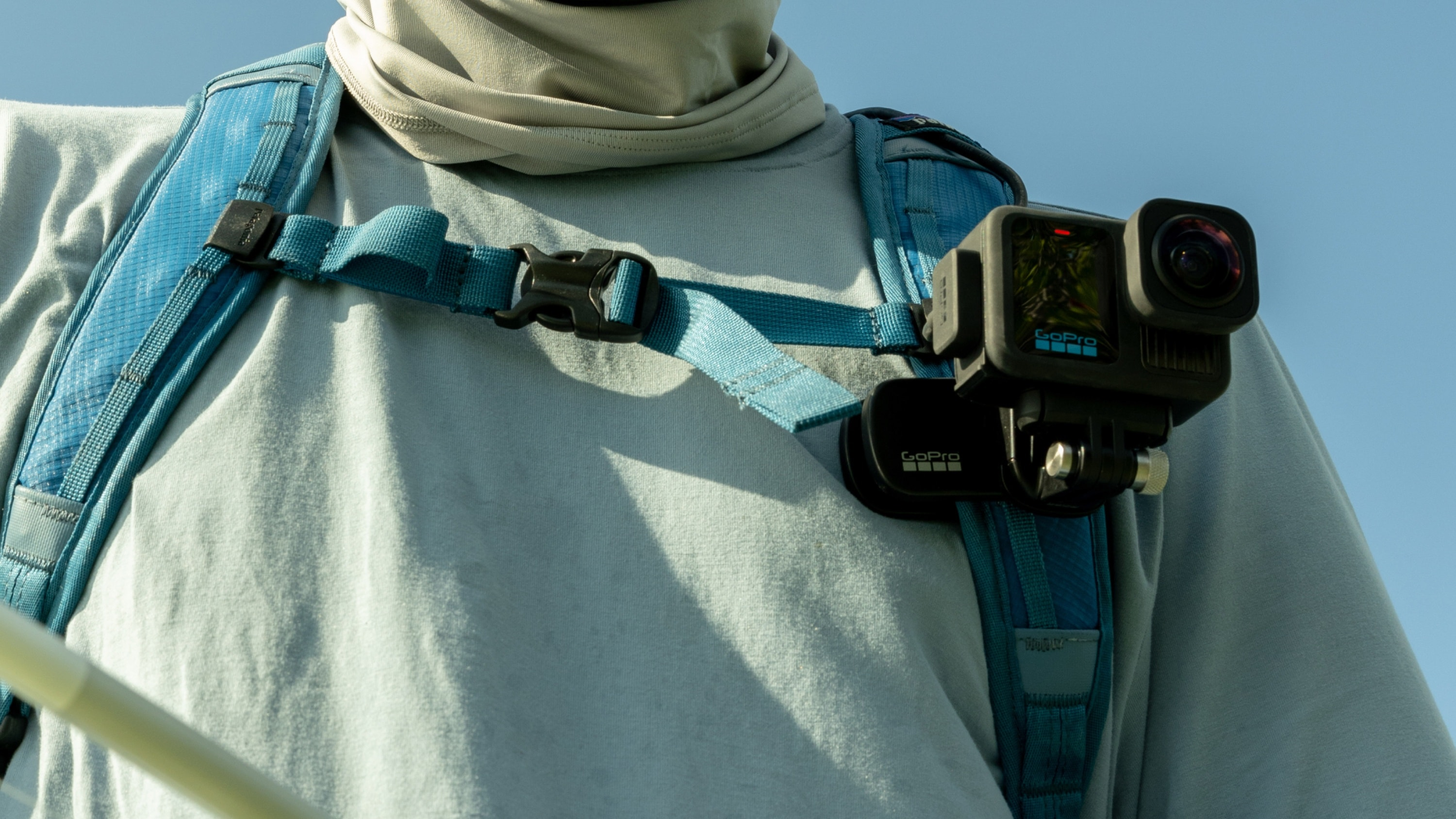Person mit hellblauem Hemd und einer GoPro-Kamera, die am Brustgurt befestigt ist.