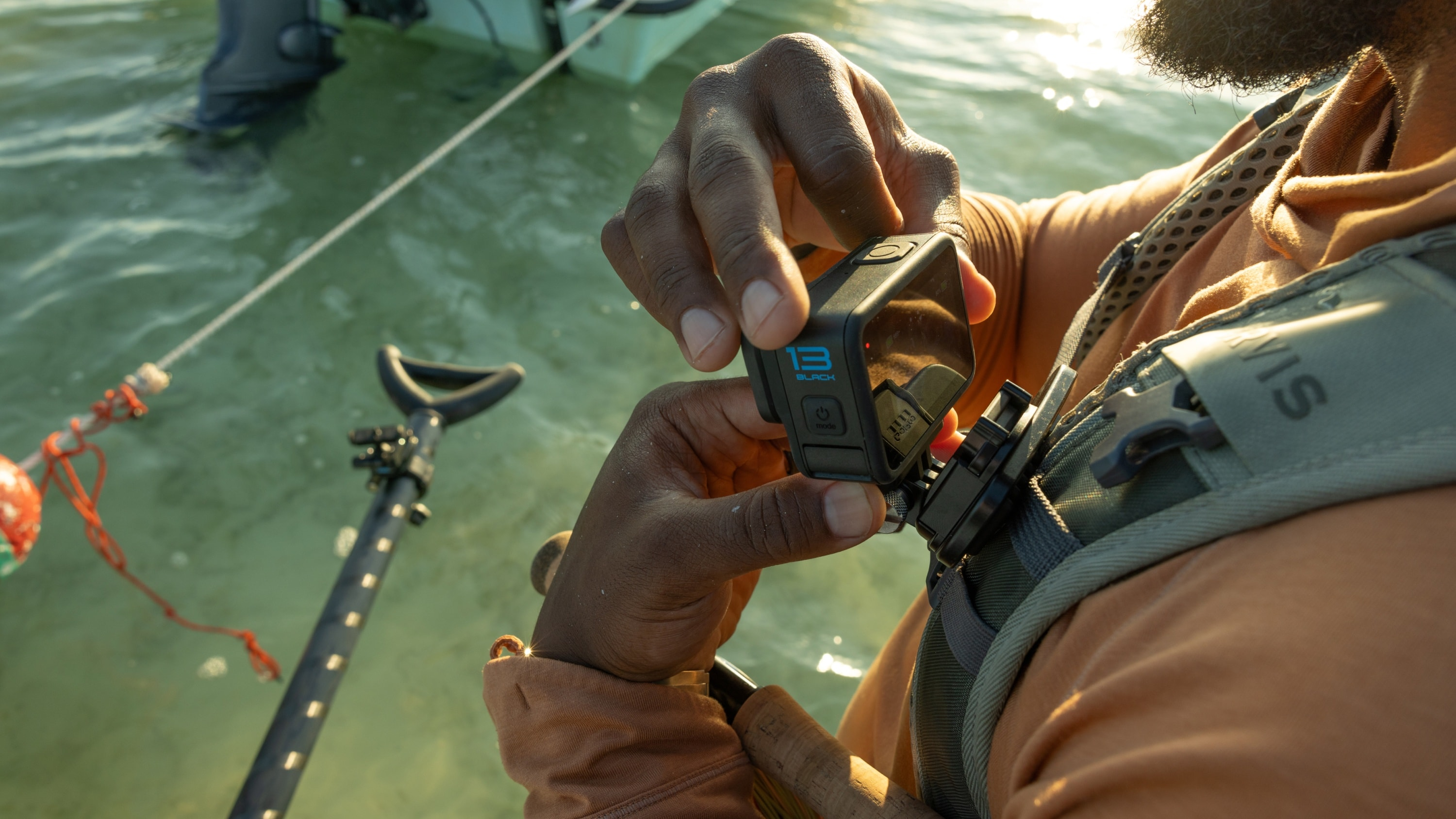 Eine Person befestigt eine GoPro-Kamera an einem Brustgurt im Wasser.